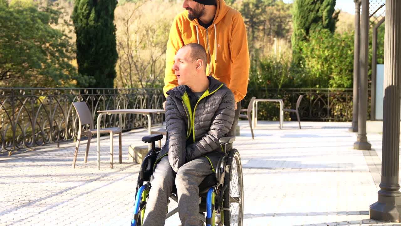 Man pushing boy in wheelchair outdoors