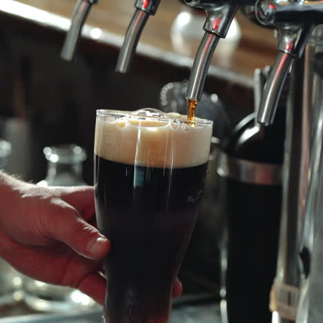 bartender pouring glass of stout beer. sqare video