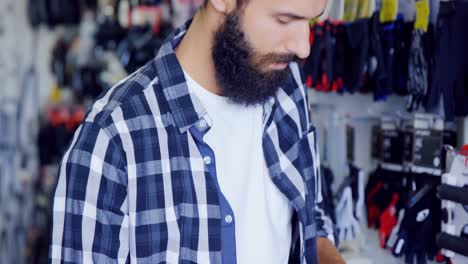 Mechanic-checking-gloves-in-workshop