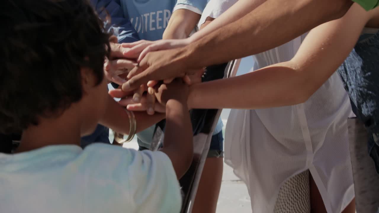 voluntarios formando una pila de manos en la playa 4k