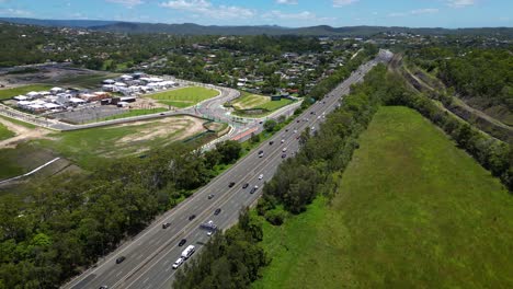 Vista-Aérea-En-Movimiento-Hacia-Adelante-Sobre-Worongary,-M1,-Skyridge-Y-La-Línea-Ferroviaria-Cerca-Del-Desarrollo-De-Skyridge,-Gold-Coast,-Queensland,-Australia