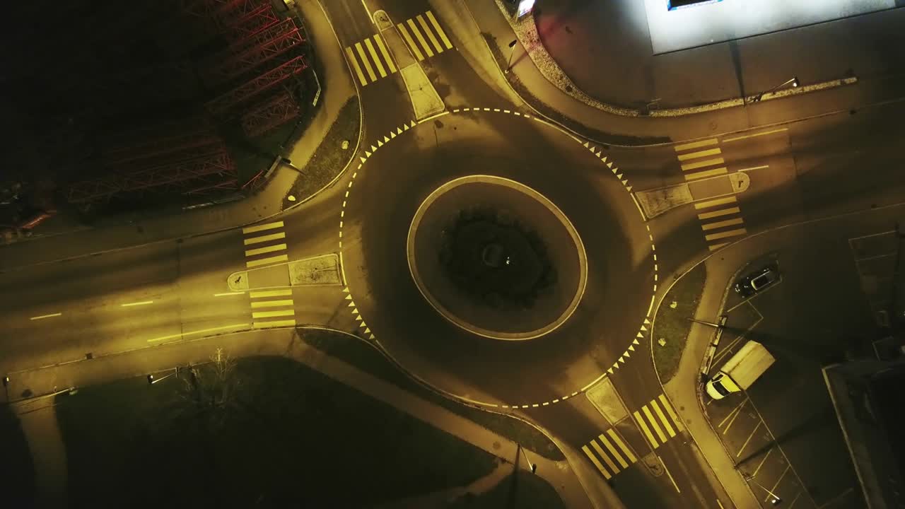 cruce de carreteras redondas por la noche.