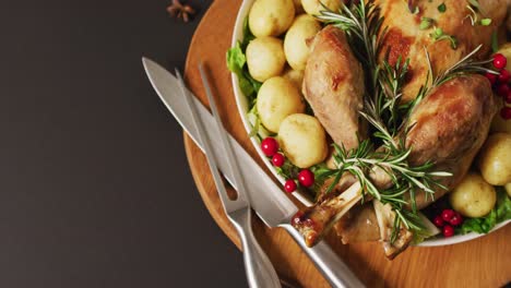 Video-of-tray-with-roasted-turkey,-potatoes-and-cutlery-on-grey-surface