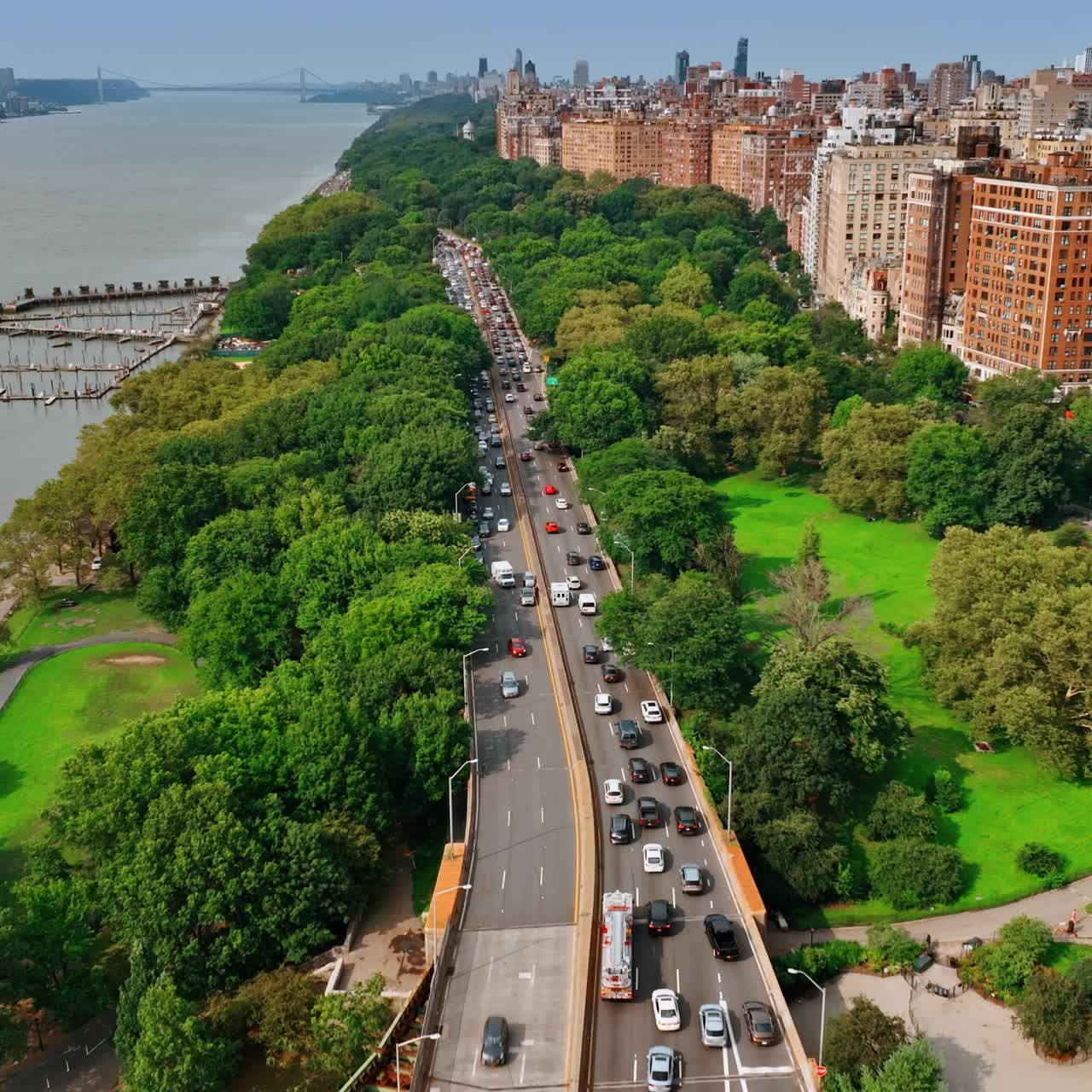 Two side freeway along the green area at Hudson river waterfront. Busy traffic on the roads of New York at day. Top view
