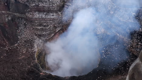 Smoke-and-steam-rise-from-volcanic-mountain-summit-crater,-geology