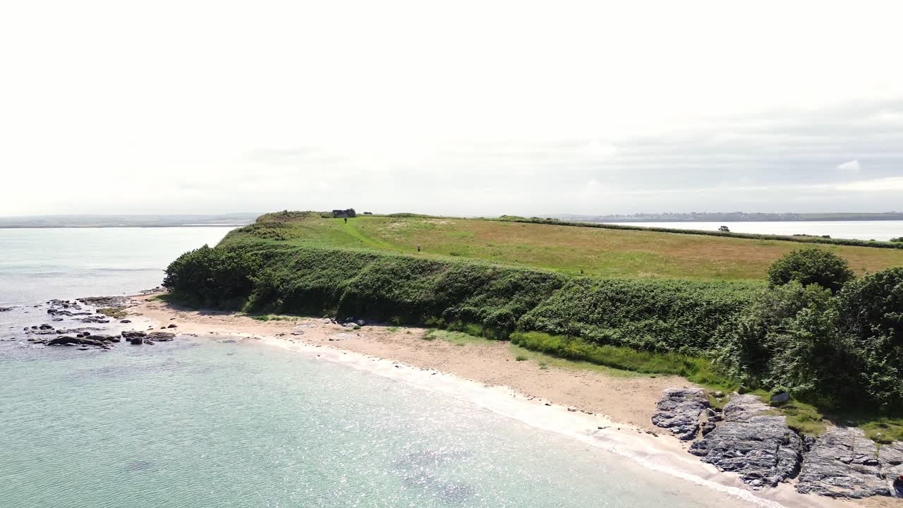 Penrhos coastal meadow headland aerial view overlooking rocky Sunny Welsh seafront beach