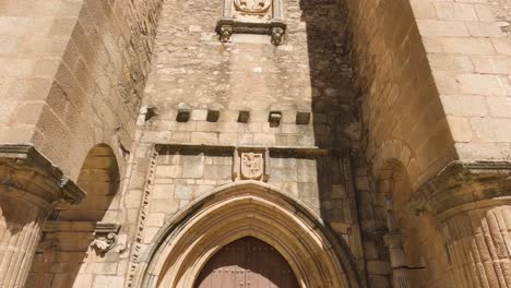 Tilt-up-from-doorway-entrance-in-Santiago-el-Mayor-Church-in-Cáceres,-Spain