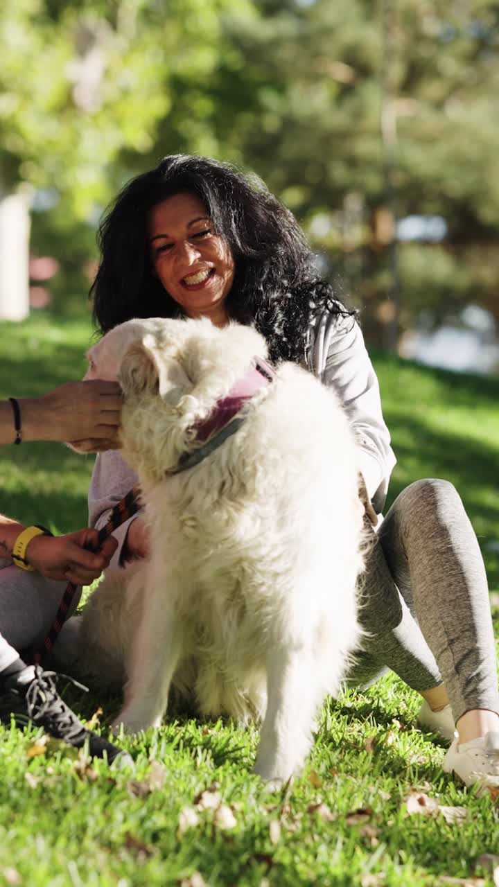 Happy Woman and Her Dog Relaxing in a Sunny Park