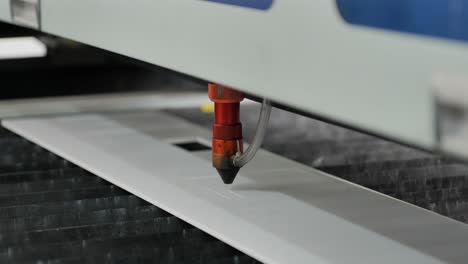 A-Laser-Cutting-Machine-Cutting-a-Piece-of-White-Perspex