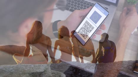 animación de un hombre con pasaporte covid en un teléfono inteligente sobre la vista trasera de diversos amigos en la playa