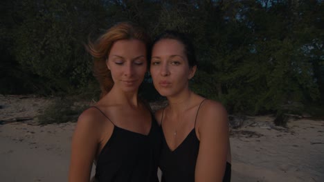 two women on a tropical beach at sunset
