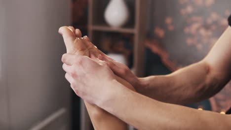 close-up of male hands doing foot massage