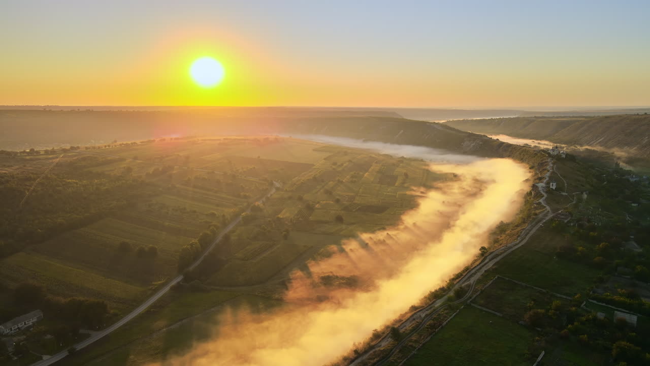 Aerial drone view of the Old Orhei at sunset. Valley with river and fog, village, monastery located on a hill in Moldova