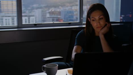 Front-view-of-young-Caucasian-female-executive-working-on-laptop-at-table-in-modern-office-4k