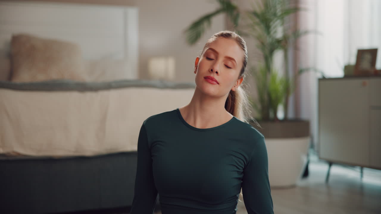 Woman doing yoga in her bedroom