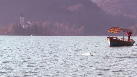 a boat passes a beautiful medieval castle and church on the shores of lake bled slovenia 2