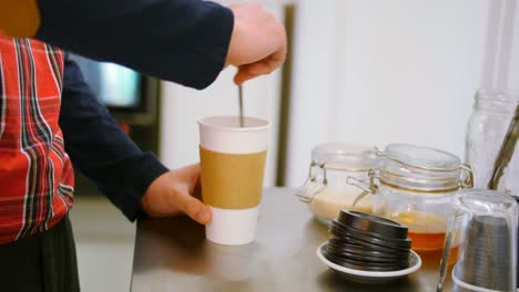 Camarero-Preparando-Una-Taza-De-Café-En-Una-Mesa-De-Acero