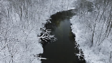 Aerial-view-from-a-drone-capturing-the-serene-winter-stillness-of-the-snow-covered-Huron-River-Valley