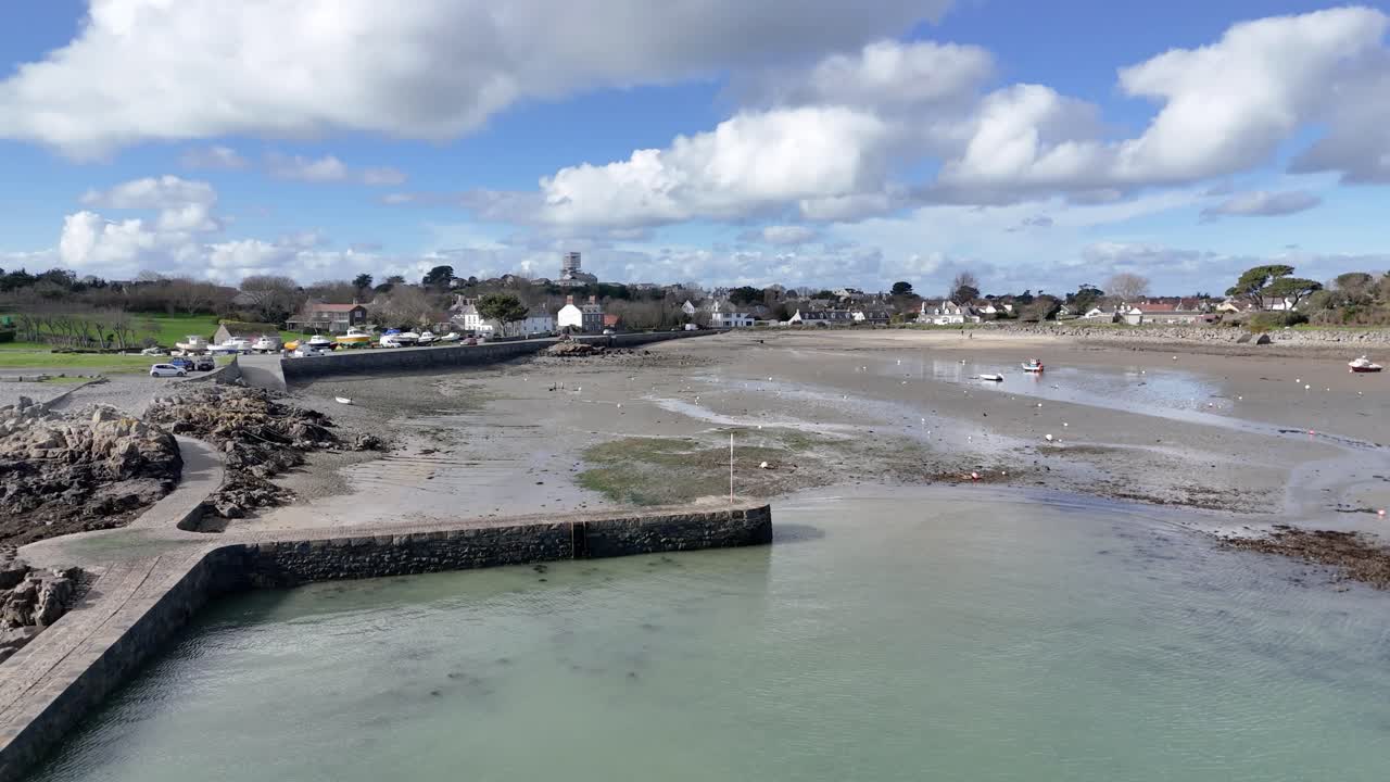 bordeaux puerto de guernsey tiro de drone en círculo bajo que muestra todo el puerto en un día soleado con barcos en duras y secas y vistas sobre la playa y hacia el norte de guernsea