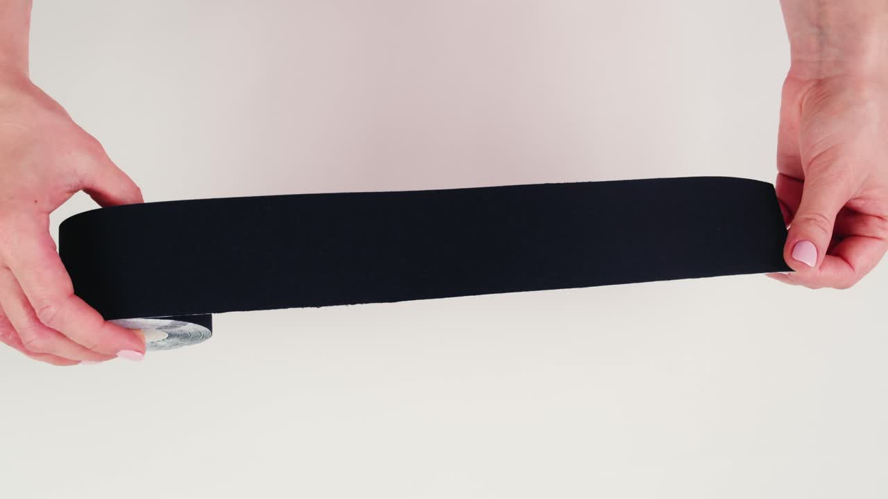 Kinesiology medical taping, doctor Physical therapist applying elastic surgical tape to patient body, treating injured knee young athlete.Post traumatic rehabilitation, sport physical therapy recovery