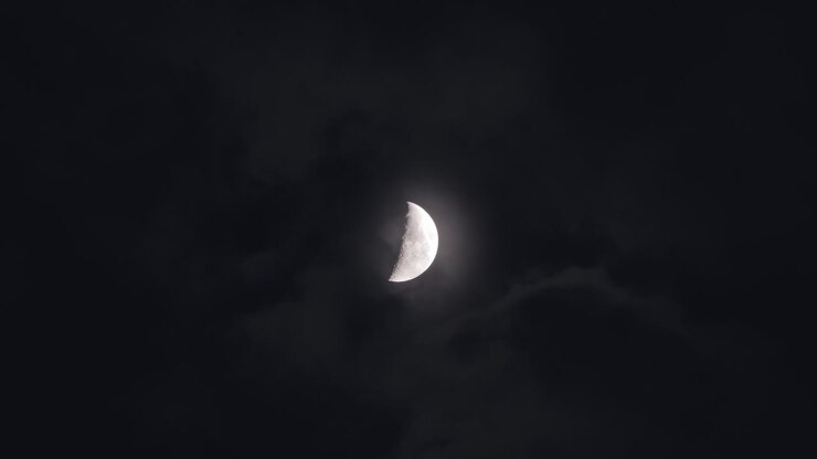 Crescent Moon Partially Hidden Behind Clouds