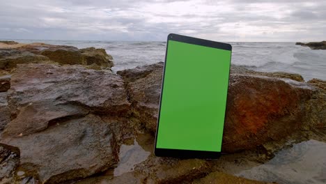 Touchpad-electronic-key-chrome-tablet-standing-on-a-rock-by-sea