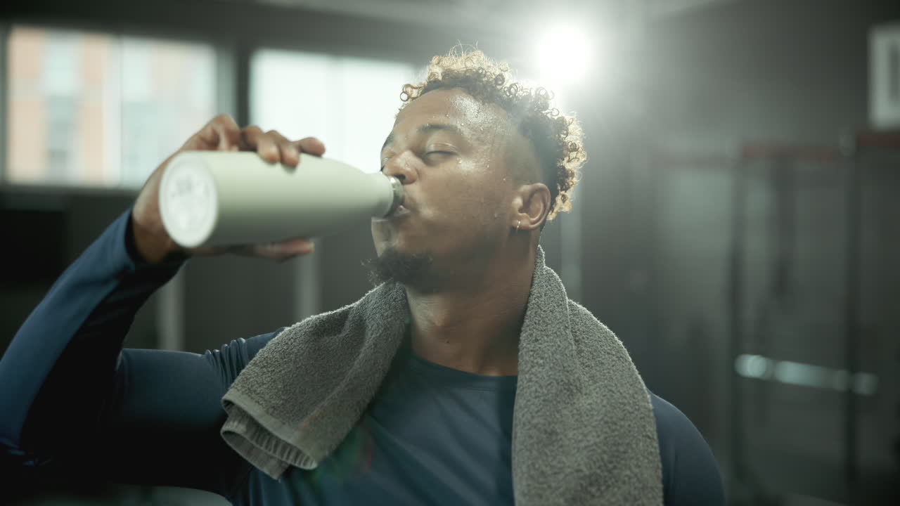 hombre bebiendo agua después del entrenamiento