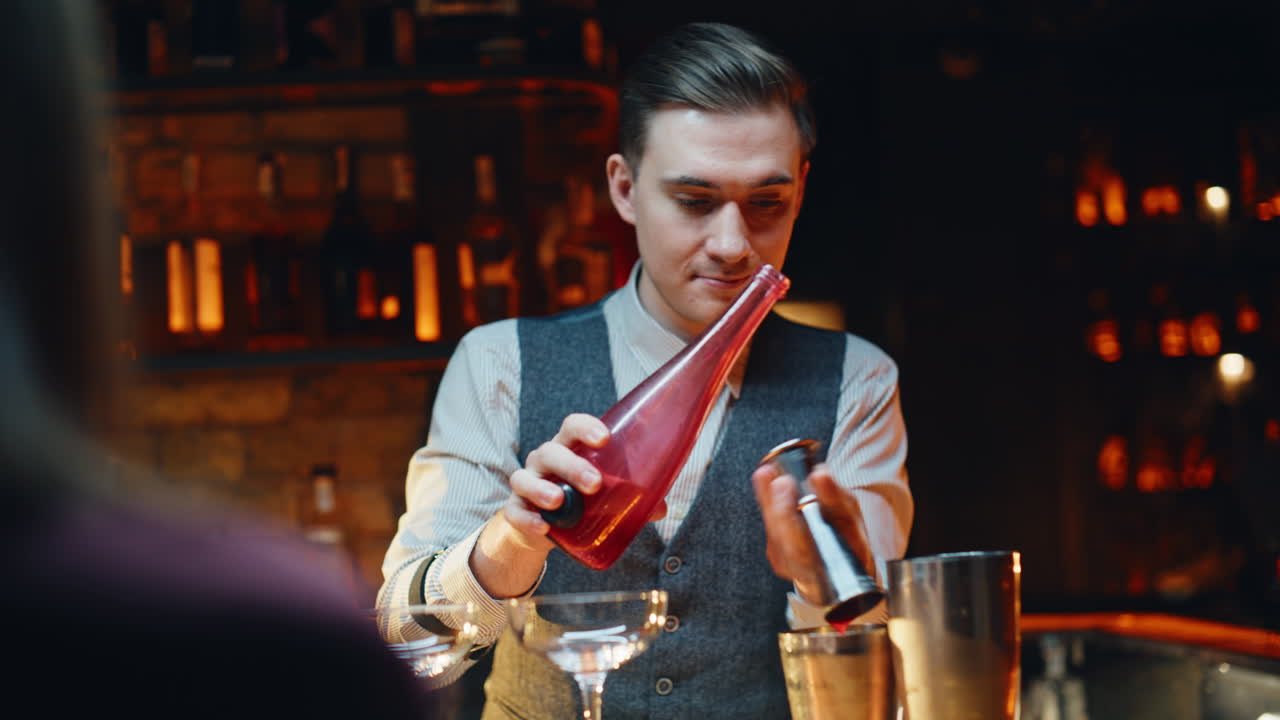 Primer plano de un barman preparando un cóctel con un medidor de cócteles en un bar. Barista trabajando en una fiesta en un club