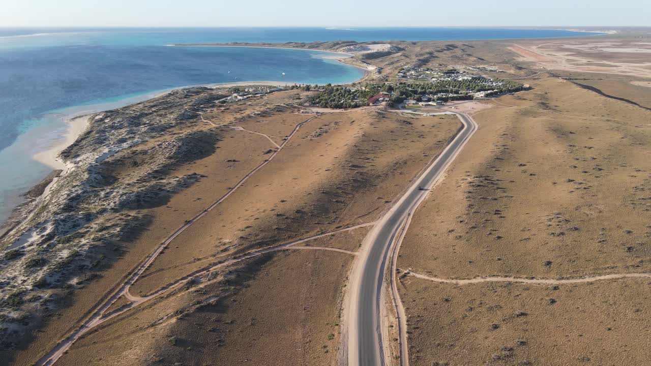 일몰 공중 촬영 60fps 슬로우 모션에서 해변에 가까운 마을로 가는 4k 시골 길