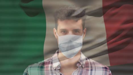 Animation-of-flag-of-italy-waving-over-man-wearing-face-mask-during-covid-19-pandemic