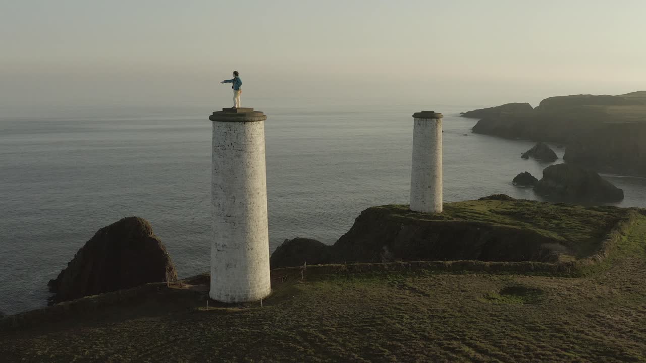 Ripresa aerea al tramonto: il faro Metal Man indica il mare in Irlanda