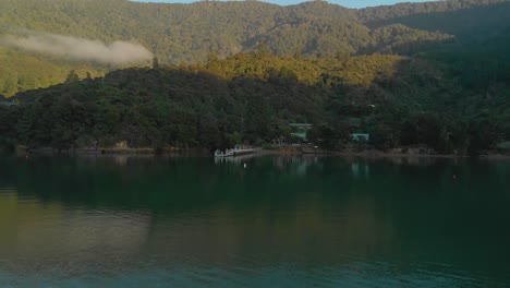 Aerial-flying-over-sea-towards-beach-in-Marlborough-Sounds,-New-Zealand,-cinematic-morning-shot