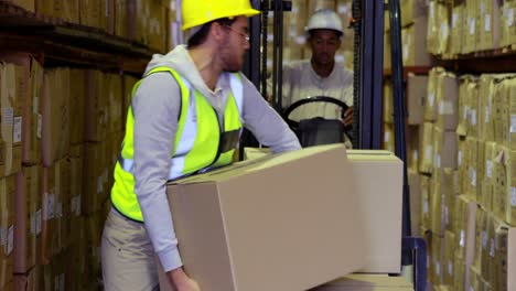 warehouse worker packing boxes on forklift