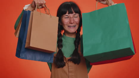 happy tourist woman showing shopping bags, advertising holidays discounts, amazed with low prices