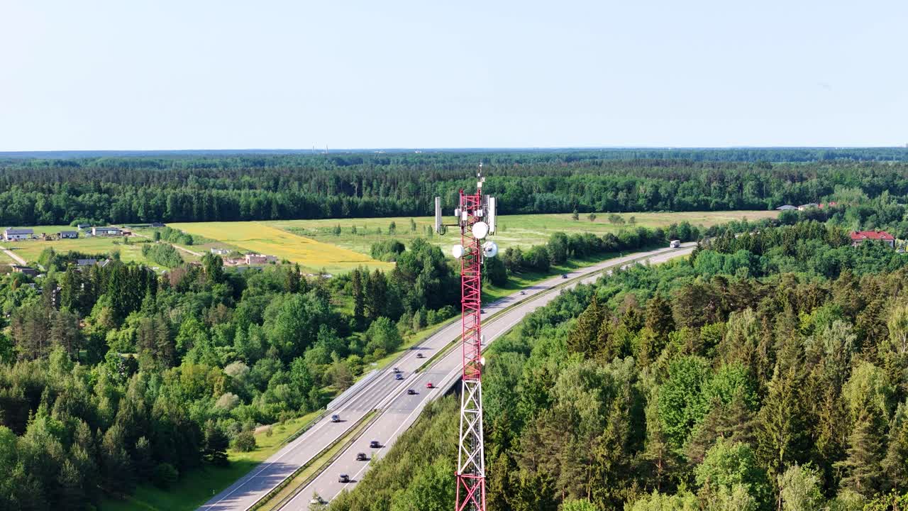 Highway road and cell tower, aerial orbit view