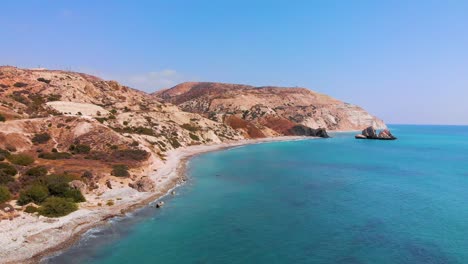 vista aérea lenta volando a lo largo de la costa de pafos hacia la roca de afrodita en la costa de paphos, chipre