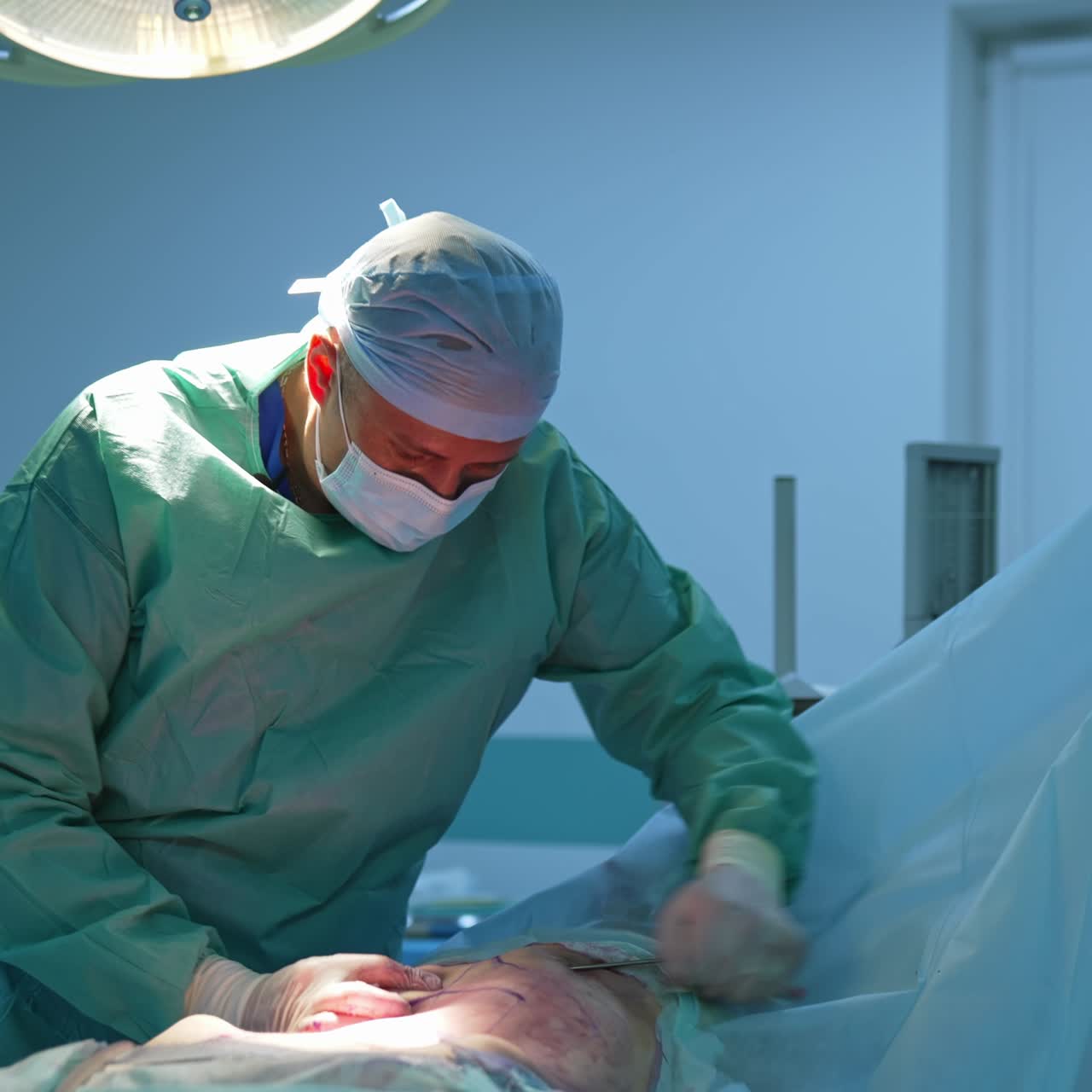 Abdominal liposuction. Surgeon performing cosmetic surgery on belly in the operating room. Body correction in hospital