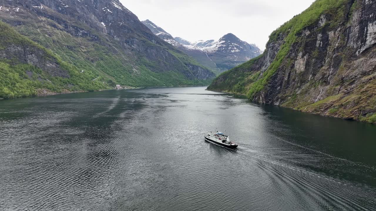 노르웨이의 geirangerfjord에서 페리 보트와 함께 관광 경로 hellesylt를 보여주는 높은 고도 항공 - 녹색 숲과 산 정상에 눈과 함께 5 월에 촬영