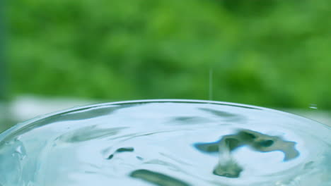 slow motion of a small drop falling on the liquid surface of a full glass