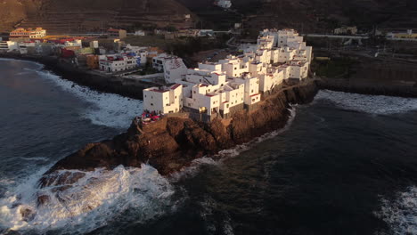 San-Andres-beach-in-Arucas:-aerial-view-with-movement-in-orbit-of-the-famous-white-buildings-on-the-beach-of-San-Andres-and-the-waves-hitting-the-coast