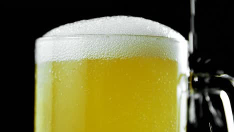 beer poured in beer mug against black background 4k