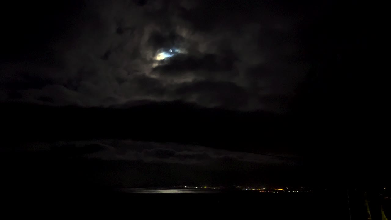 Cielo notturno illuminato dalla luna sopra città e oceano