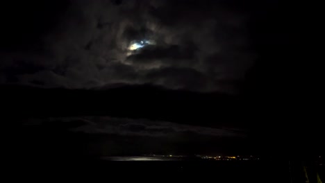 moonlit night sky over city and ocean