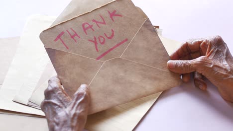 senior womens hand holding thank you note , top down