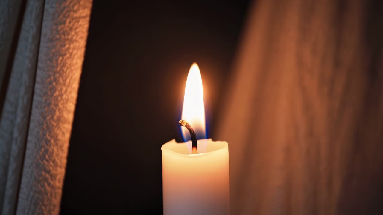 Candlelight creates a warm, inviting ambiance, casting soft shadows and highlighting textures in a dark, cozy room, perfect for relaxation or contemplation