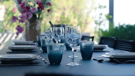 covered table with glasses and plates, completely decorated in the garden of a villa in south france