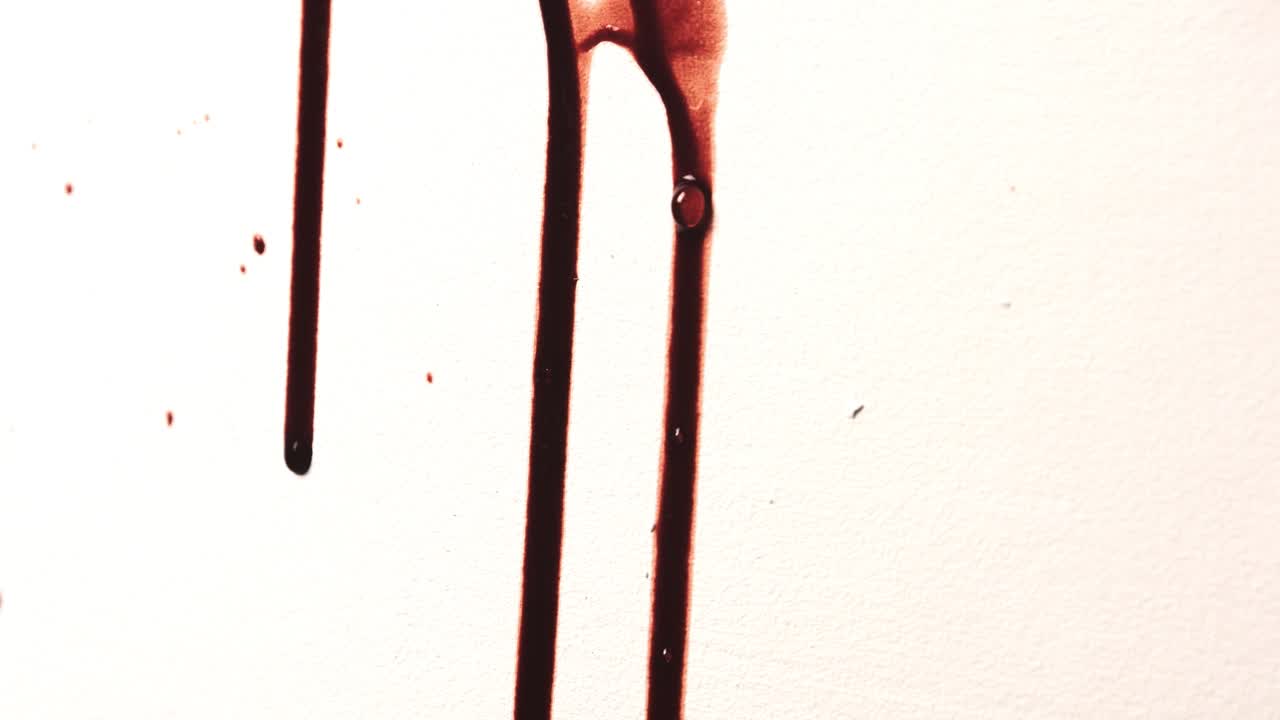 Splattered Red Fake Blood Slowly Dripping on White Wall. Shiny Thick Liquid Spatter Under Bright Light. Slime Texture for Horror. Violent Crime Scene Halloween Spooky Background