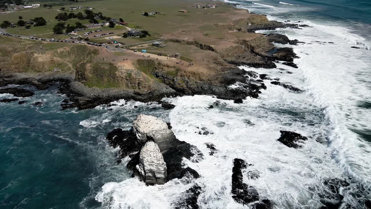 órbita aérea de las rocas de punta de lobos con pájaros en sus cimas en un día soleado y la bahía en la distancia