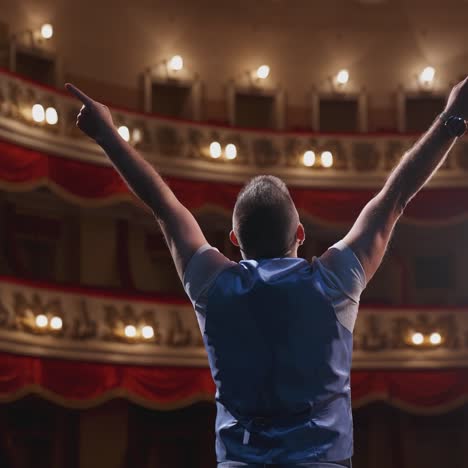 man performing with gestures on stage. unrecognizable actor standing on stage in classic theater. male actor speaks from the scene. back view.