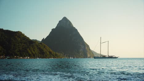 yacht in soufriere with pitons and golden evening light